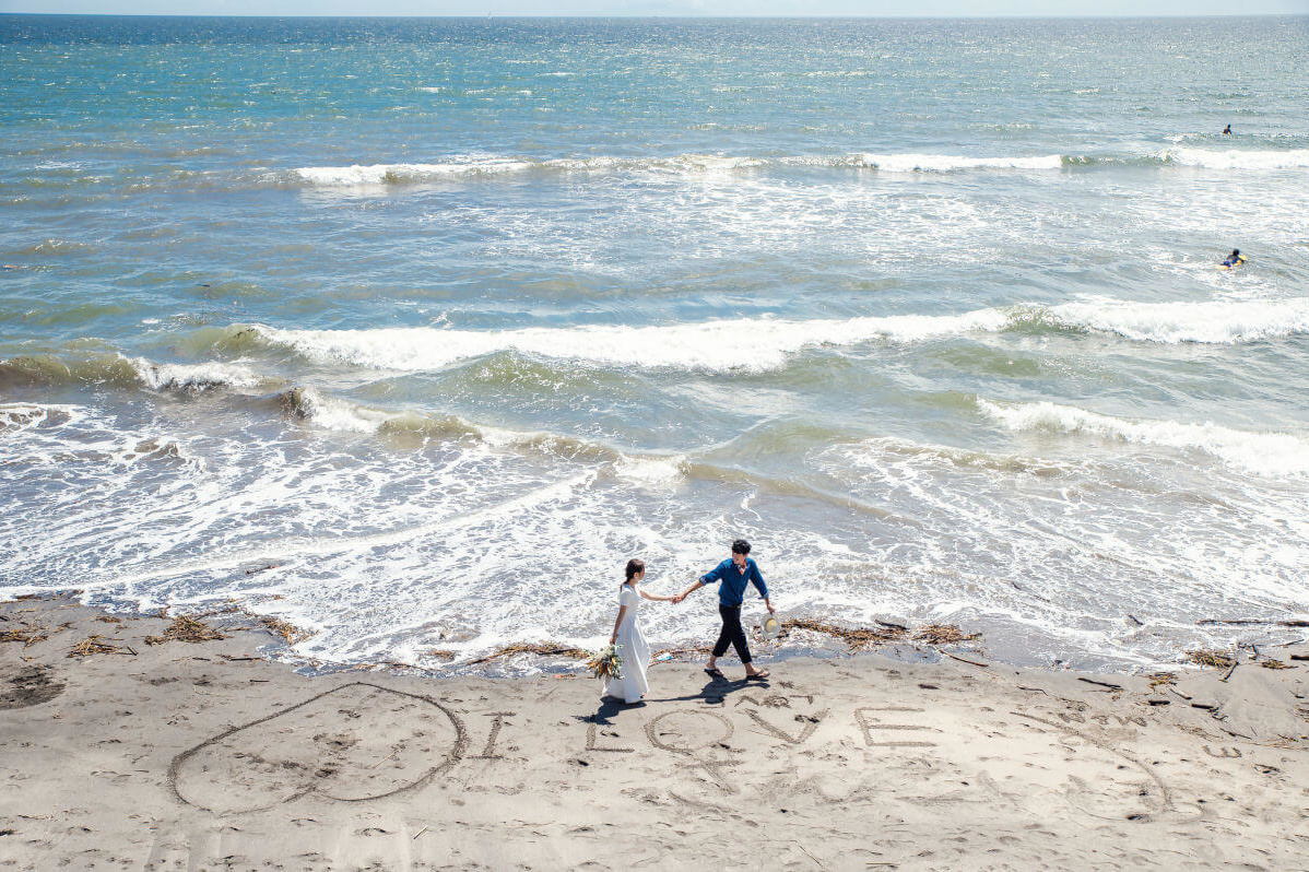 七里ヶ浜の浜辺を歩く新郎新婦