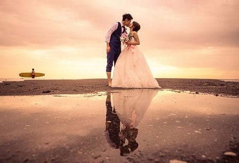 湘南海岸でキスをする新郎新婦