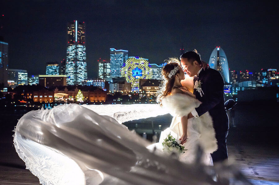 みなとみらいの夜景に映える新婦のドレスとベール