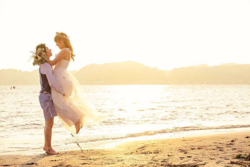 海で新婦を持ち上げる新郎