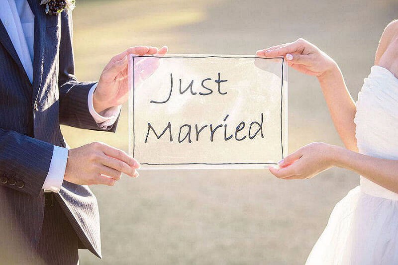Just Marriedのボードを持つ新郎新婦