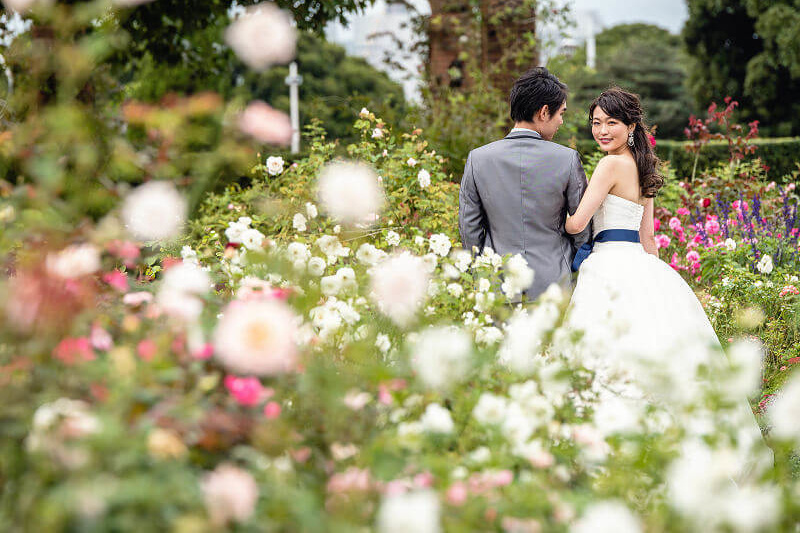 公園の花に囲まれて振り返る新婦