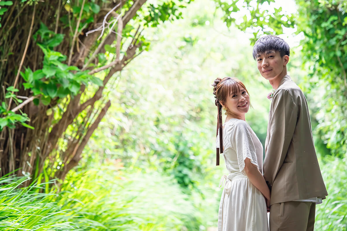 緑を背景に夕日を見るふたり