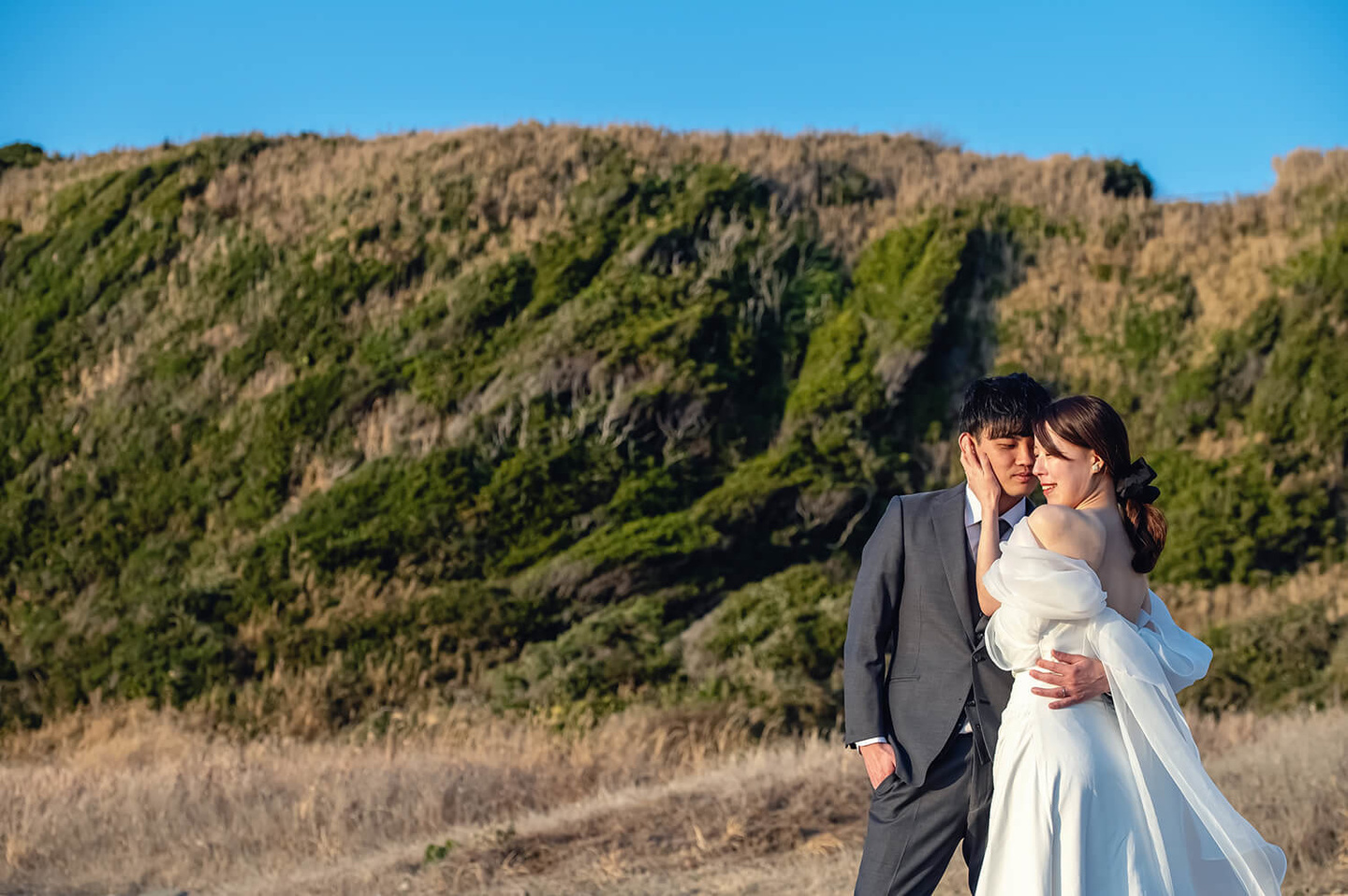 緑と空を背景に抱き合う二人