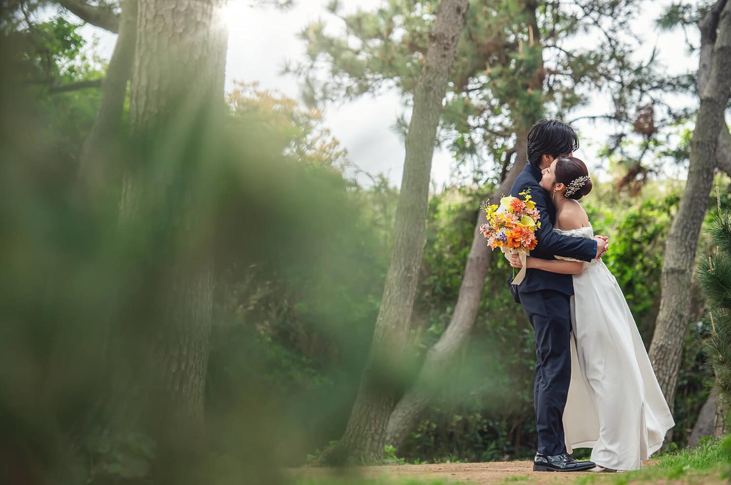 木々の中で抱き合う新郎新婦