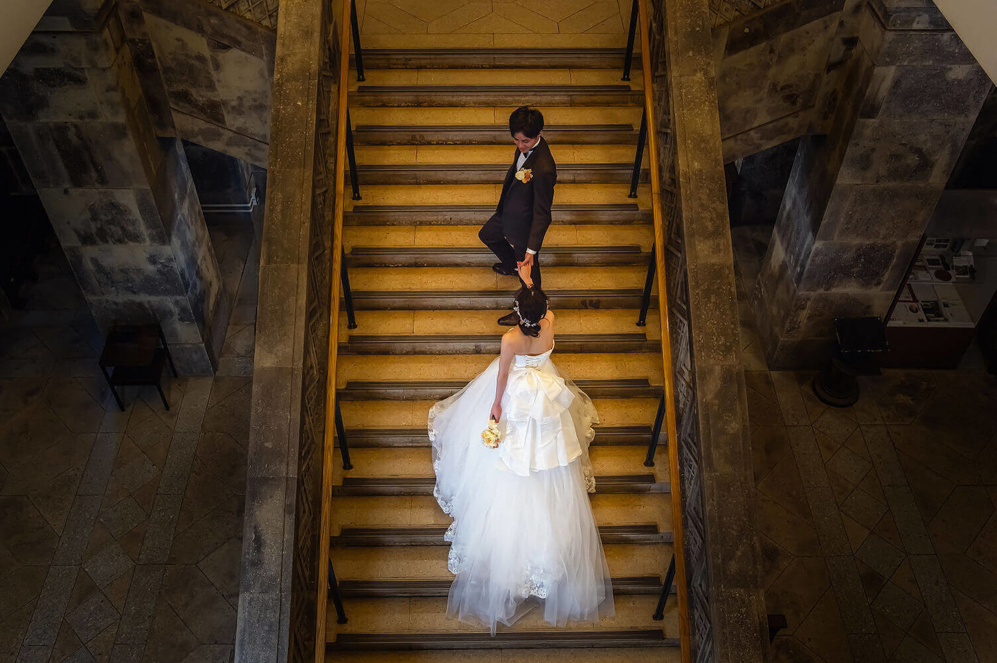 大倉山記念館の階段で新婦の手を取る新郎