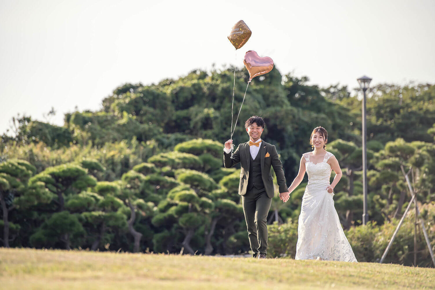 芝生エリアで風船を持って歩くふたり
