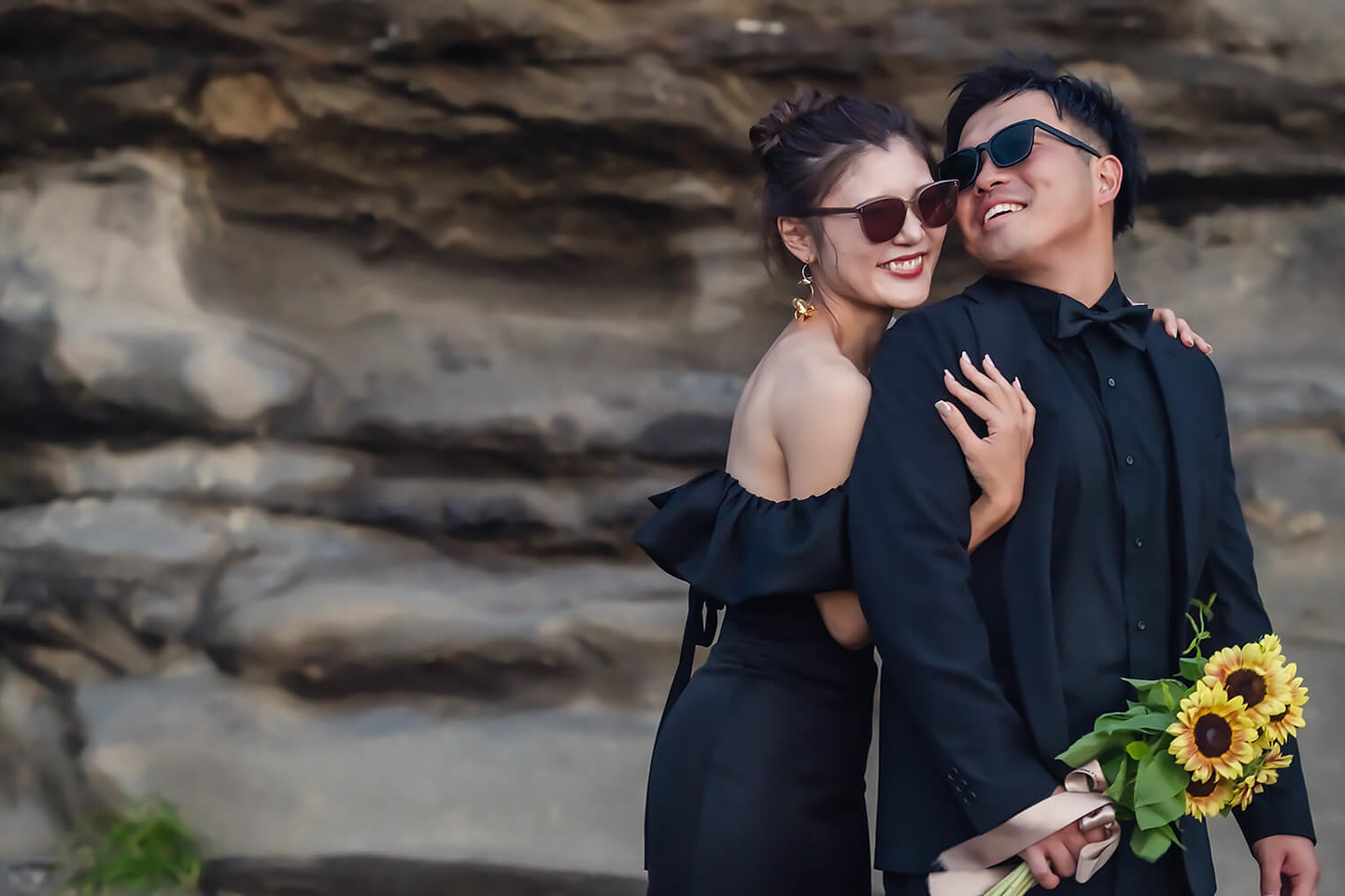 岩場の前で笑い合うふたり